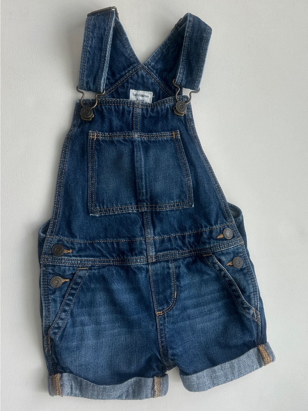 Gap girl’s highlights a classic pair medium-wash denim shortall overalls. Size 4